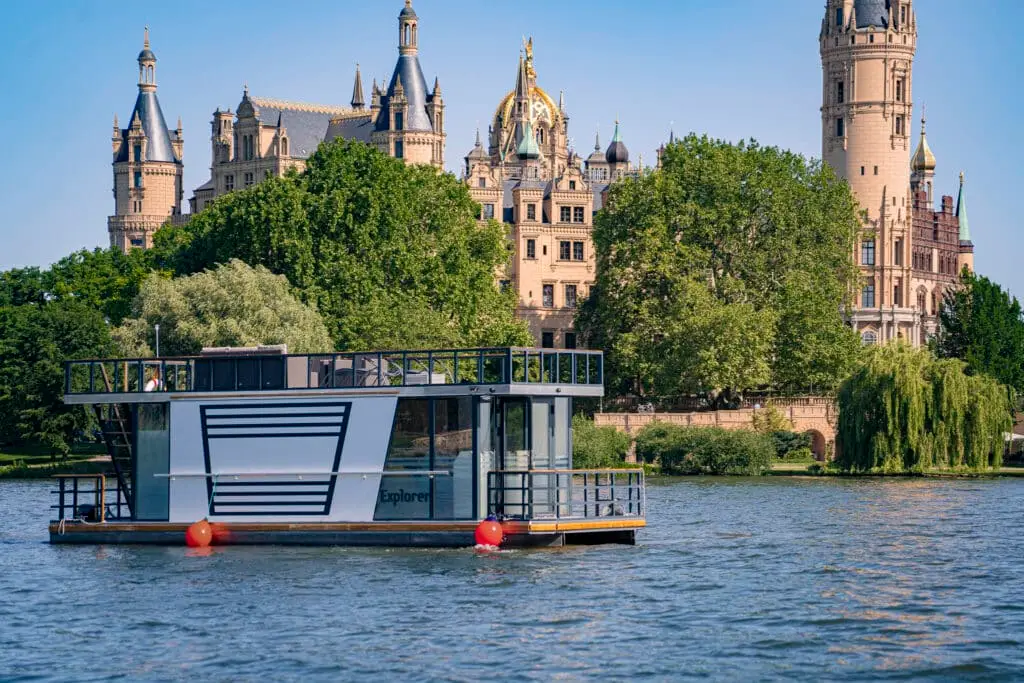 Hausboote, Hausboot Explorer bei VINDUA, wintertaugliches Hausboot fährt auf dem Schweriner See direkt am Schloss zum Anleger, Jetzt eines unserer Hausboote buchen